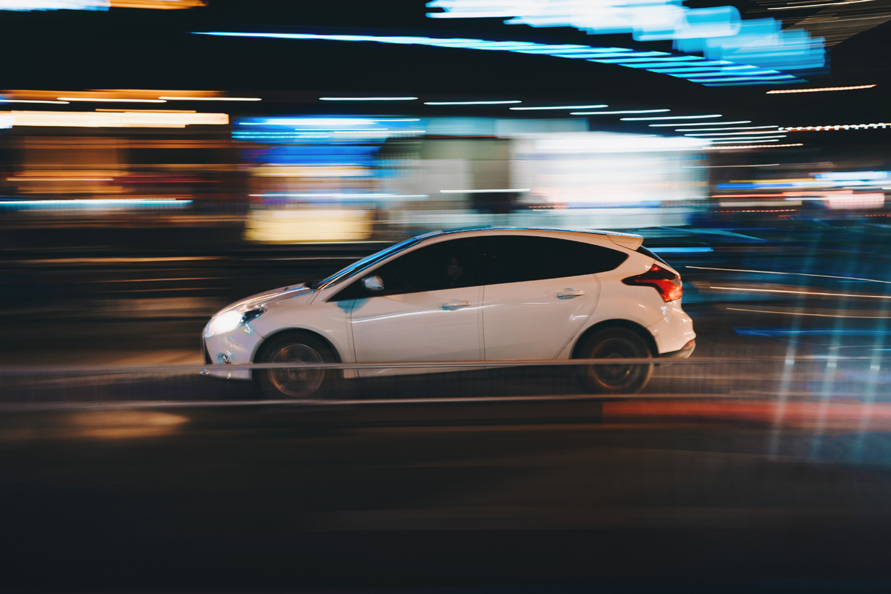 夜の街を走る白い車